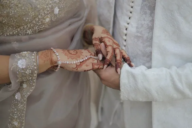 A bride and groom, hands joined